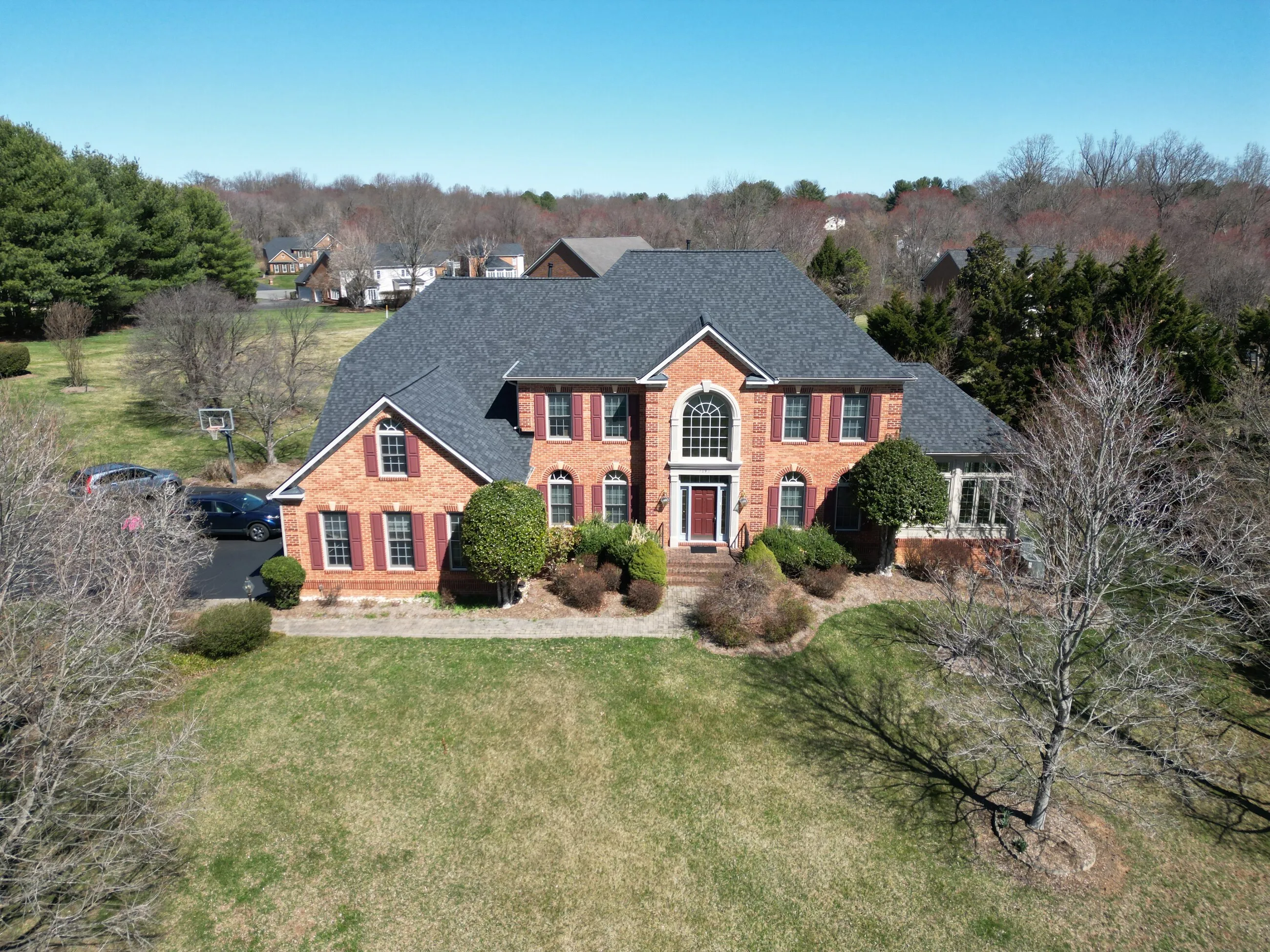 Aerial view of a brick colonial home with a new architectural shingle roof
