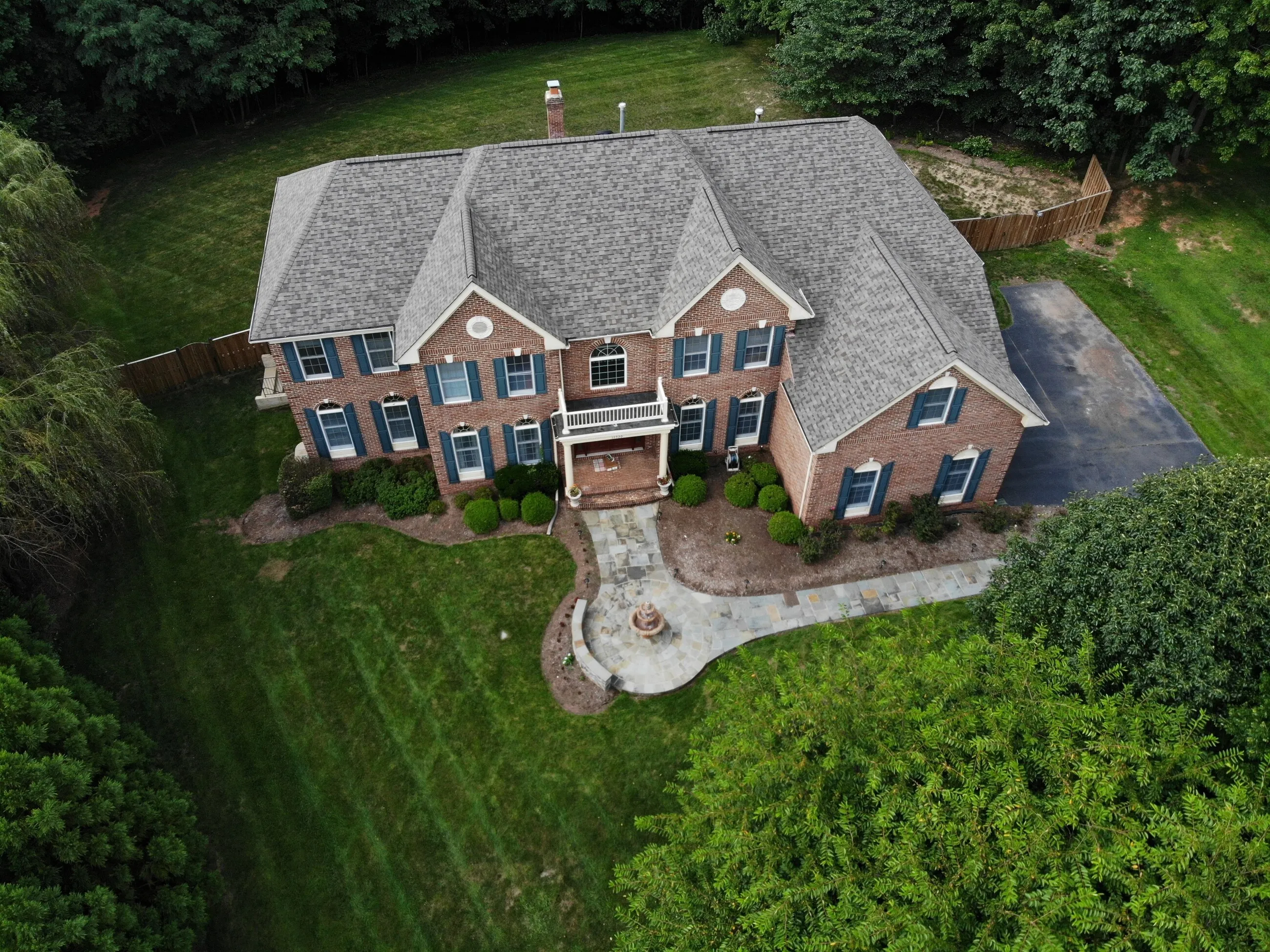 Aerial view of a brick Georgian home with a new architectural shingle roof