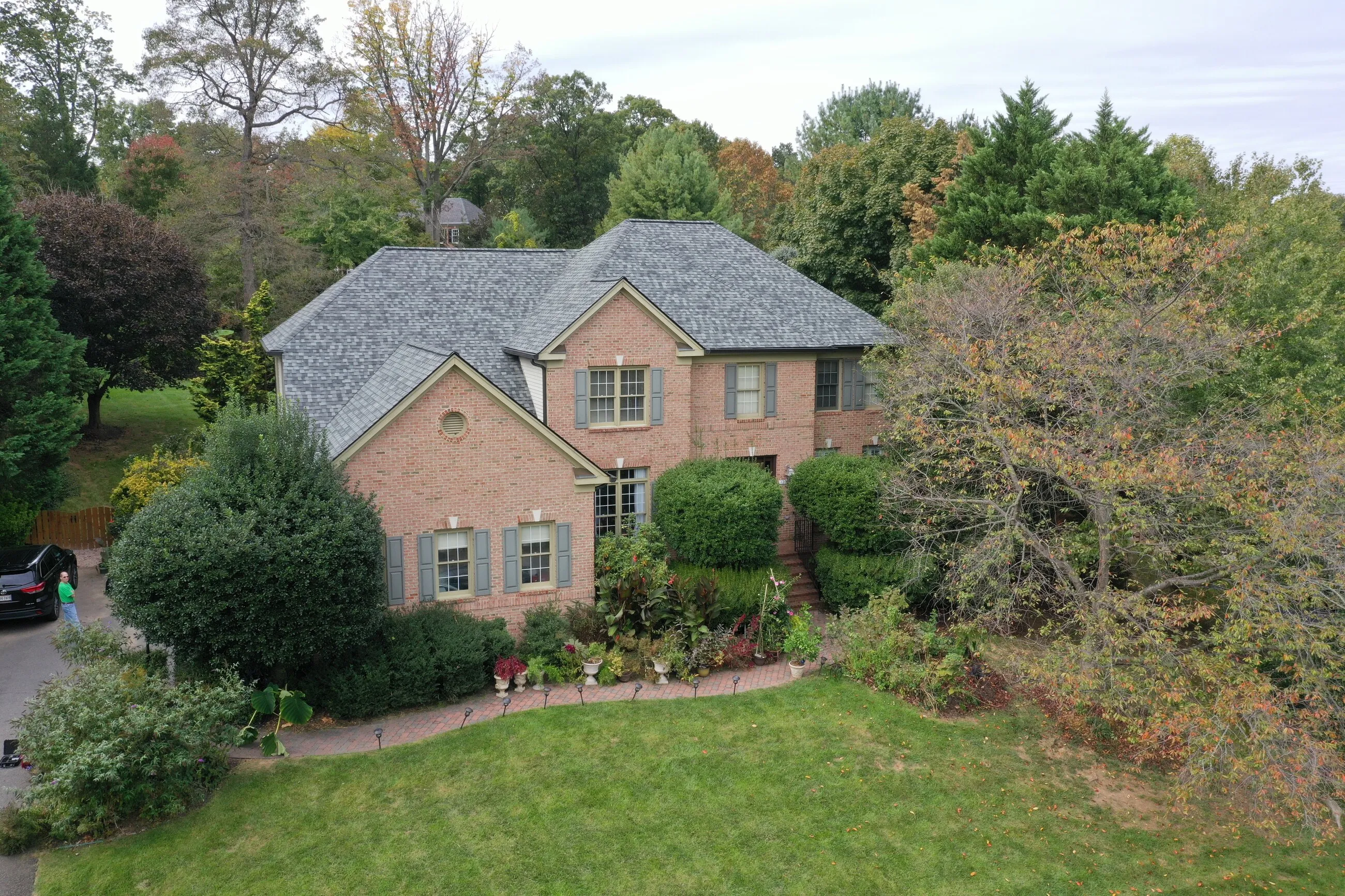Aerial view of a brick colonial home with a new shingle roof