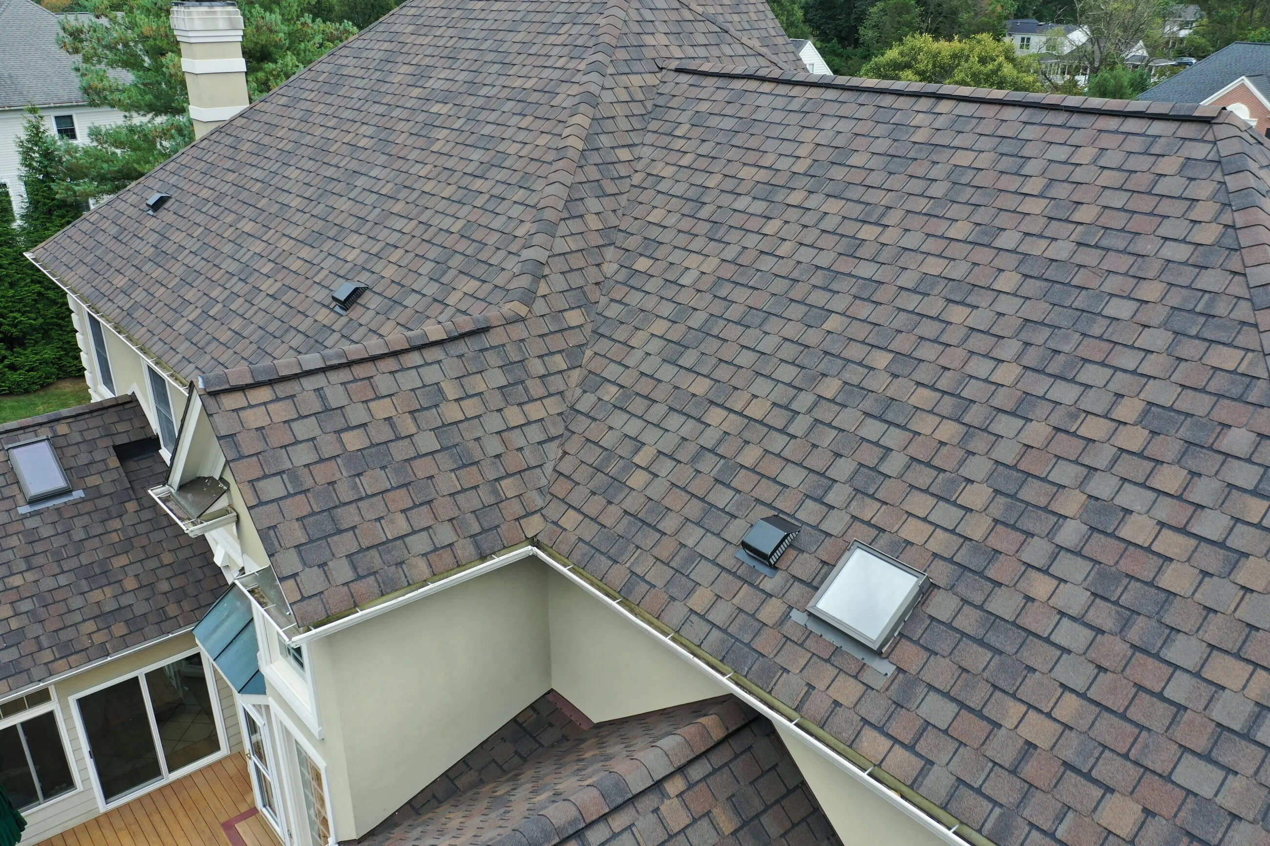Designer shingle roof in a brownstone blend with a new skylight over a bay window
