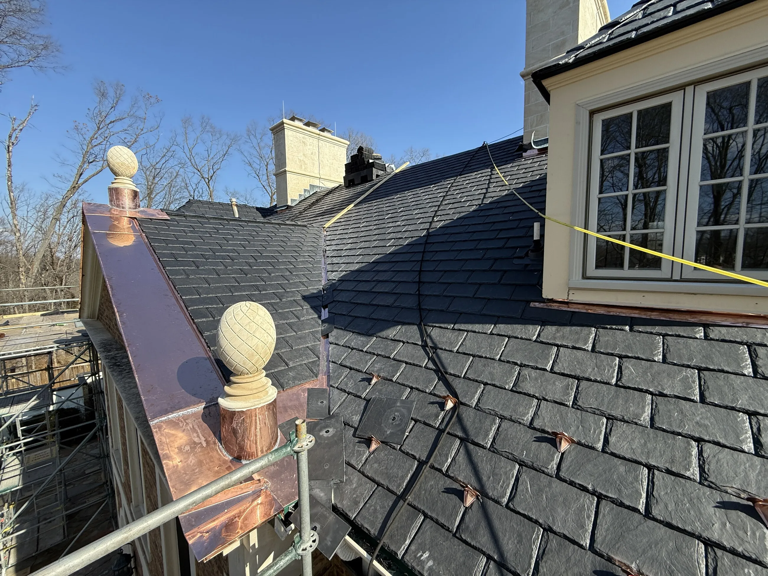 Slate roof with copper ridge caps and decorative copper finials
