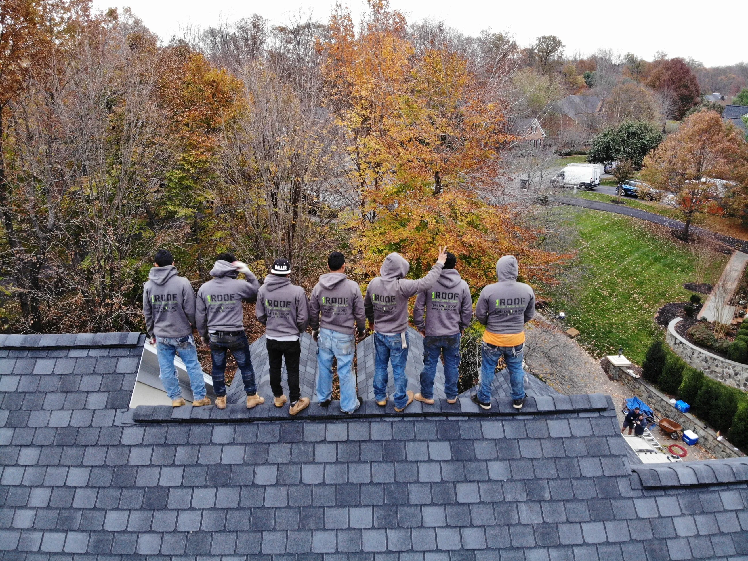 The 1ROOF crew standing together on a completed slate roof overlooking a Northern Virginia valley