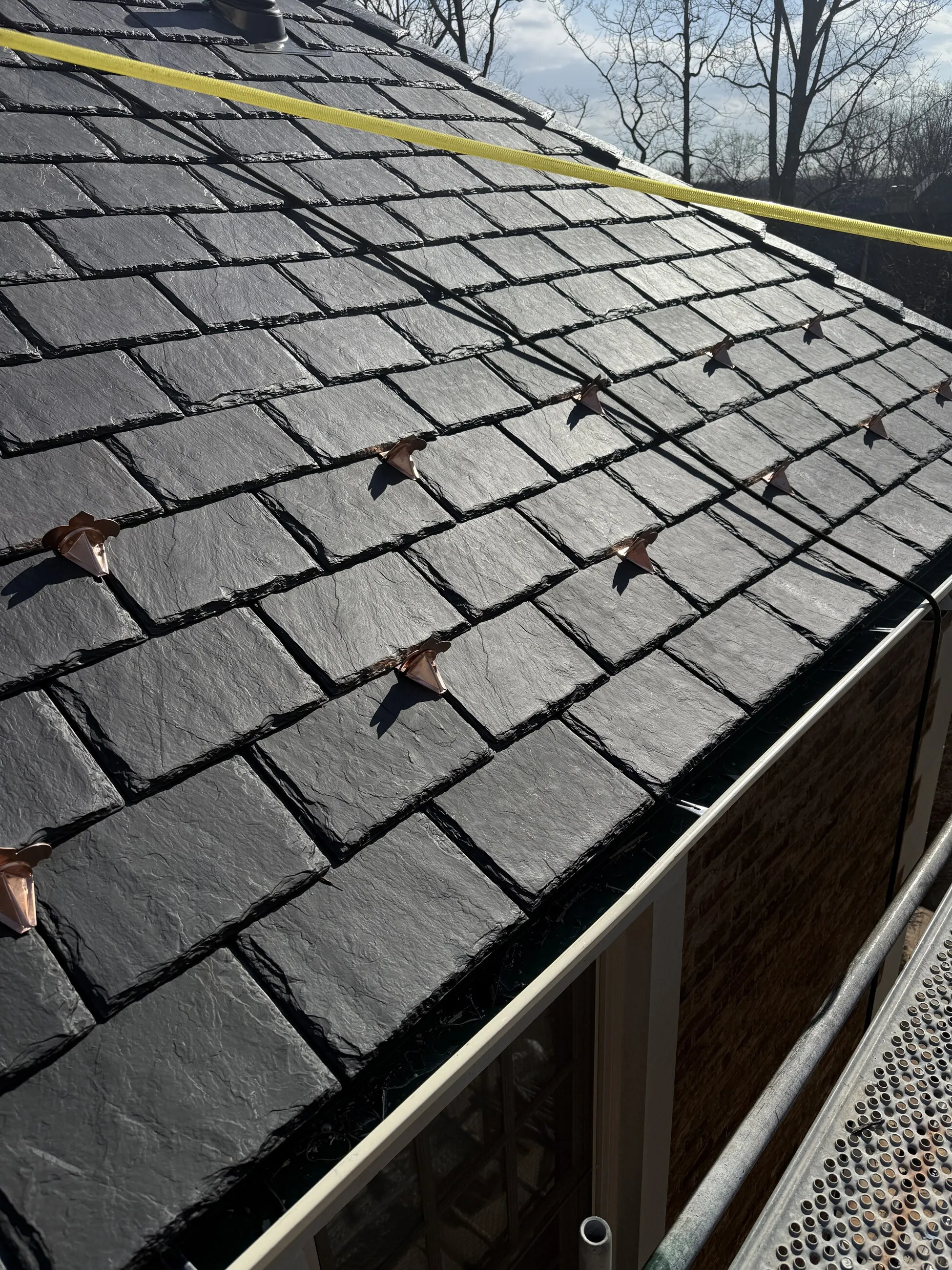 Close-up of slate roofing with copper snow guards