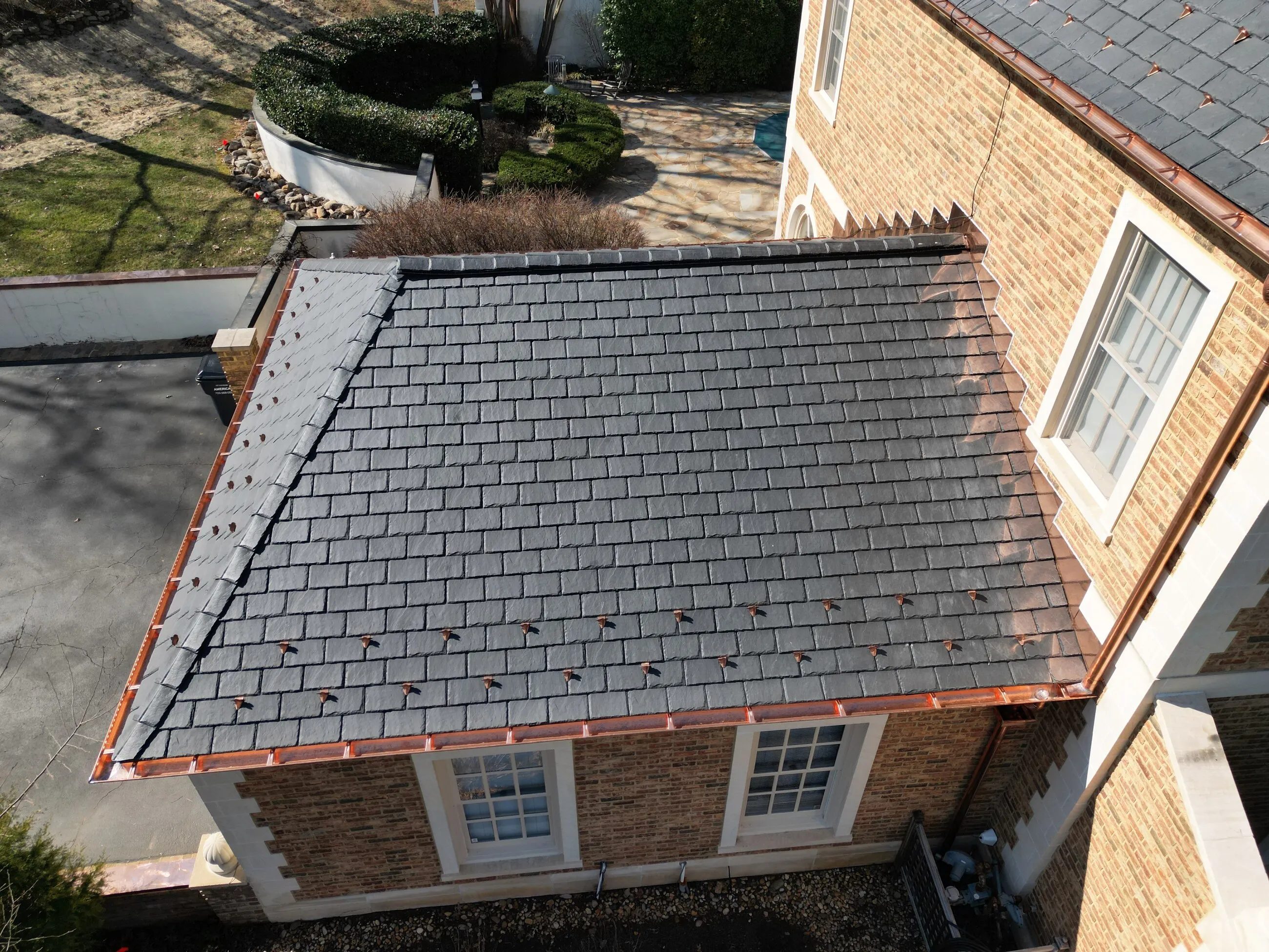Slate roof over a brick garage with copper gutters and snow guards