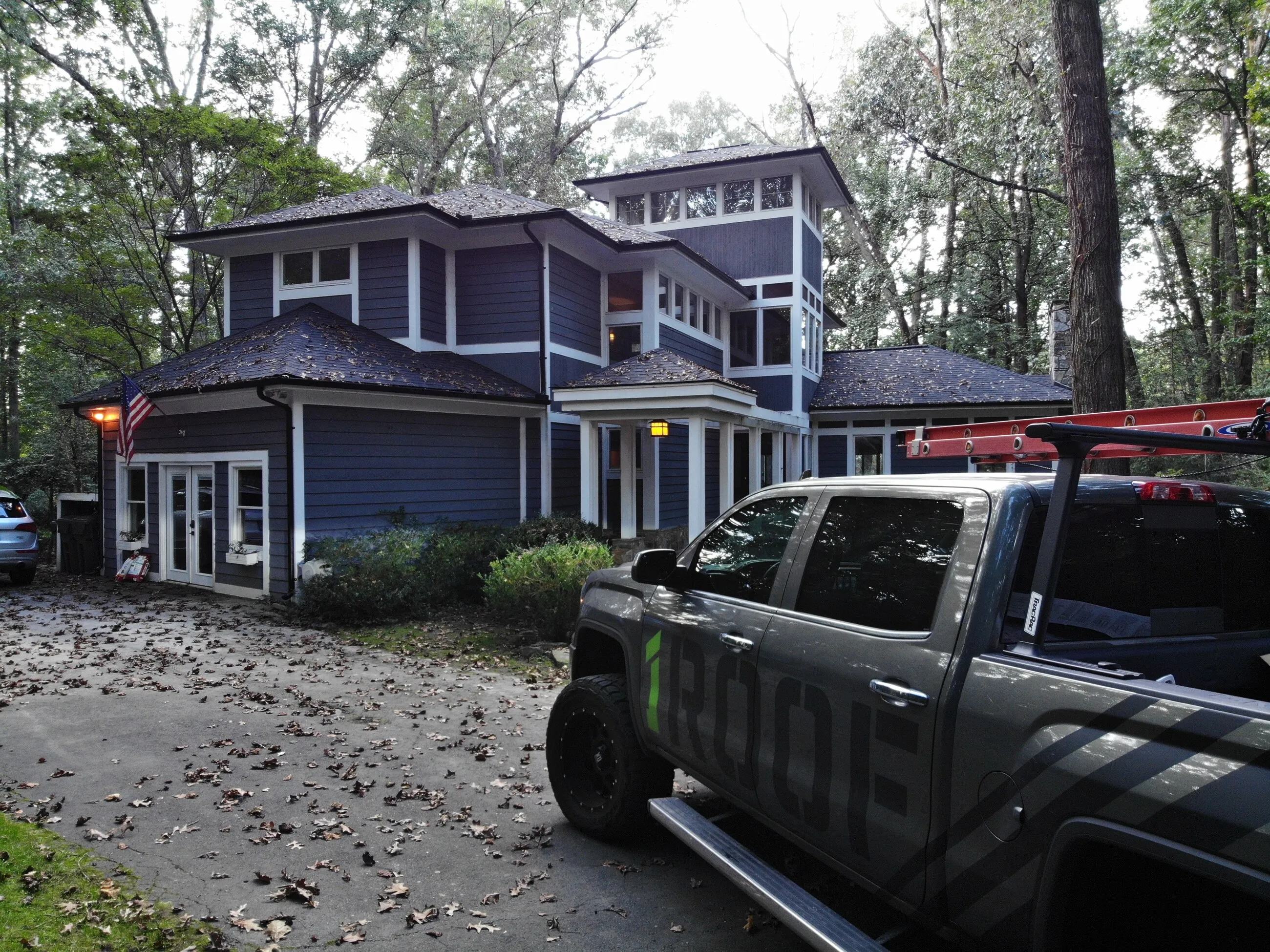 1ROOF truck parked at a job site in front of a craftsman home